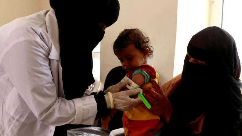 De doktersassistent meet de omtrek van de bovenarm van een kind