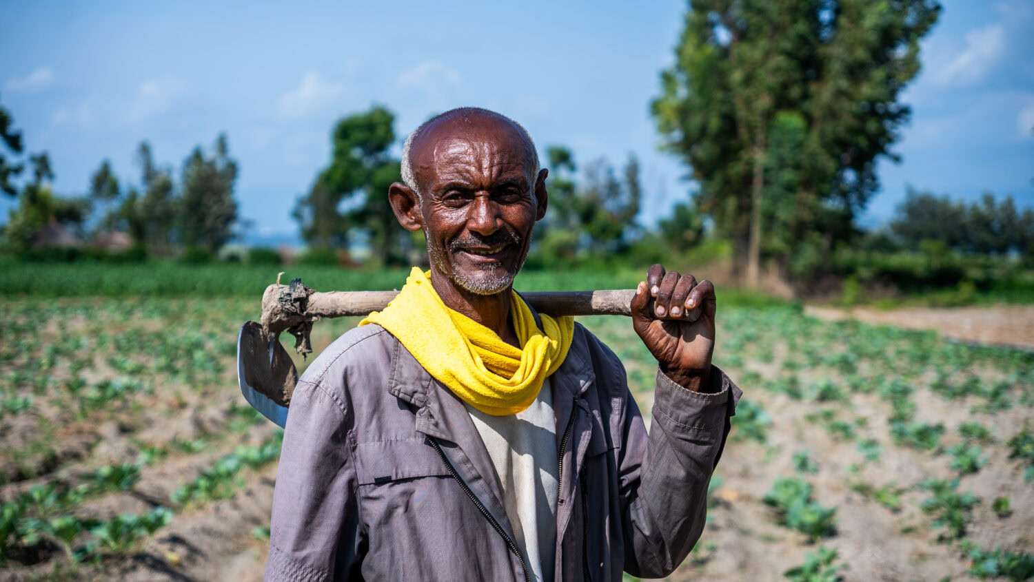 Zwarte man met schop op veld in Afrika, sociaal project, landbouw, ontwikkeling, dorcas.