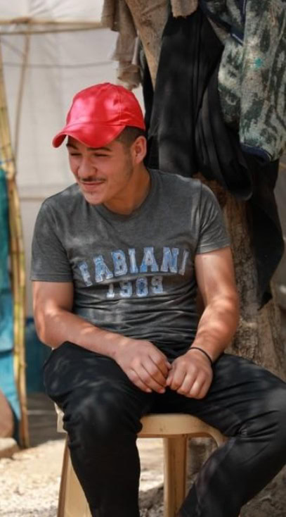 Broer Jawad: Man met rode cap en grijs T-shirt, lachend 