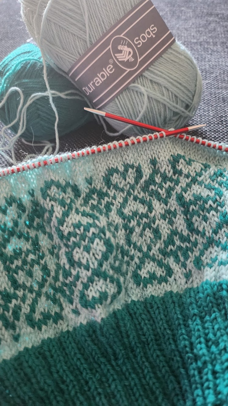 Draad, breipennen en een kleurrijk gebreid patroon voor handwerk en creativiteit.