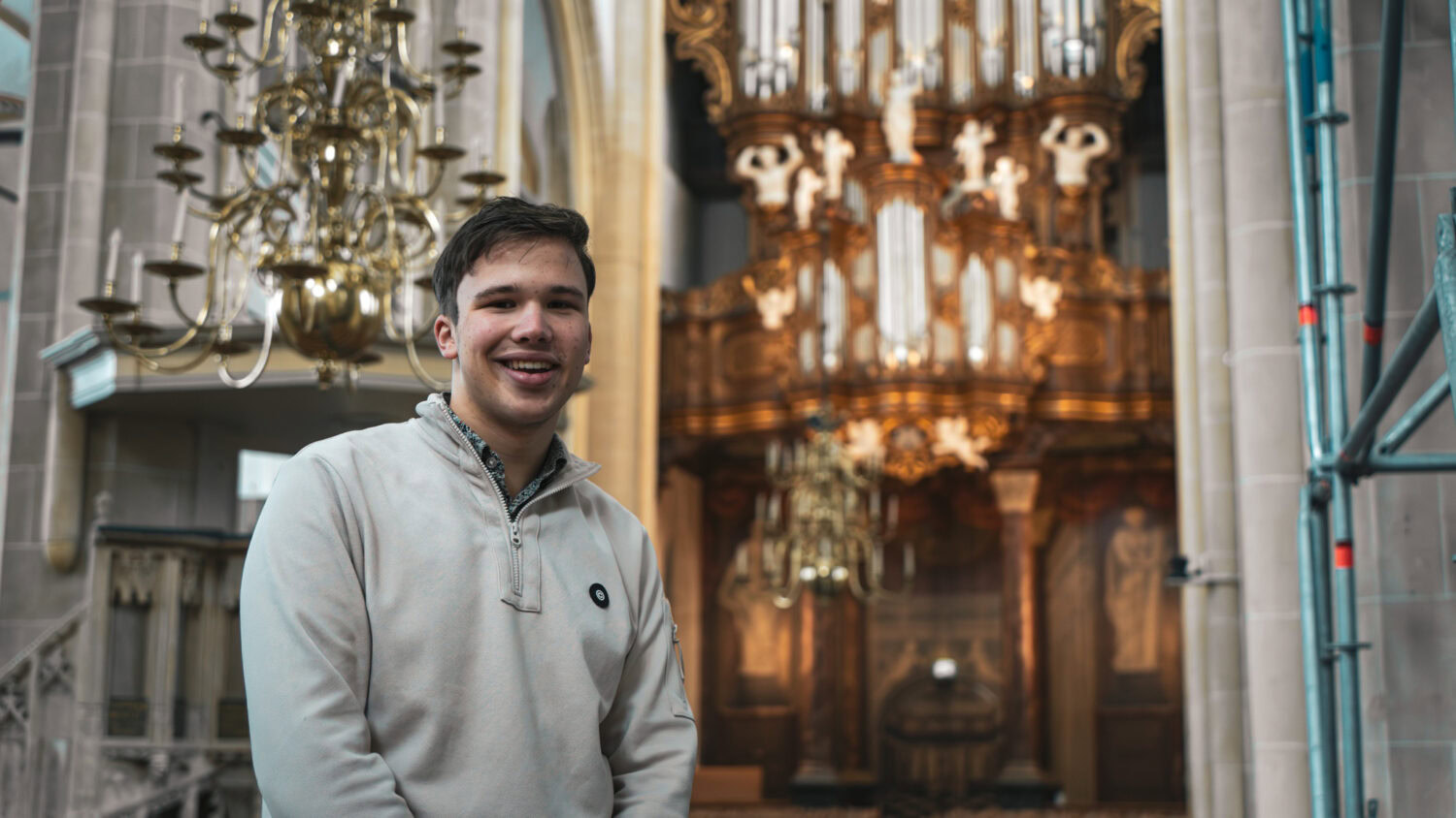 Frederik (17) speelt orgel in de Bovenkerk in Kampen tijdens een benefietactie voor Dorcas, met een grote kerk als achtergrond.